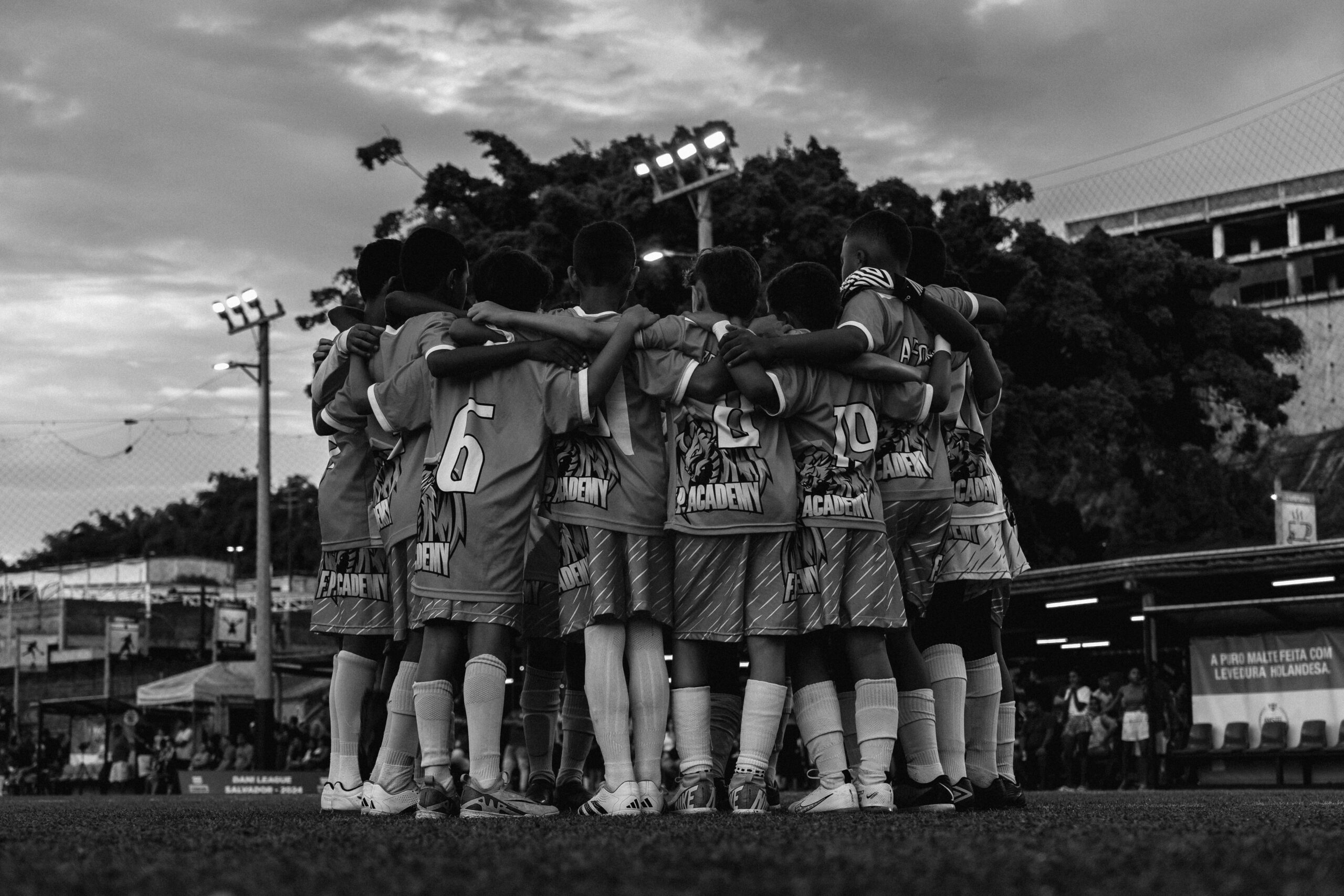 A black and white photo of soccer players huddling